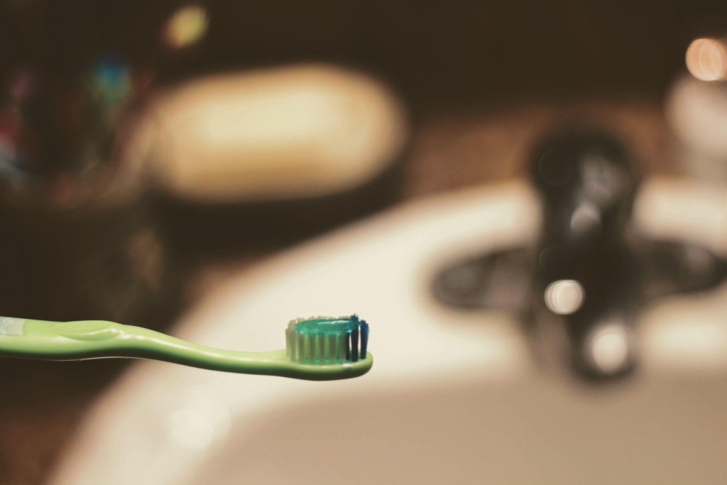 A green toothbrush with green toothpaste